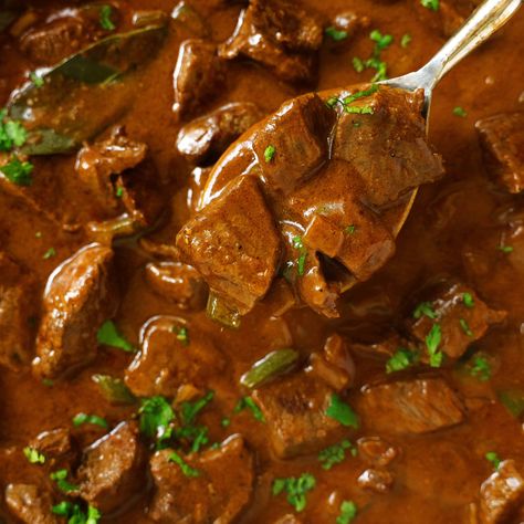 A spoon being used to dip a scoop out of a pan of Carne Guisada. The mixture is dark brown with flecks of bring green cilantro. Carne Guisada Recipe, Guisada Recipe, Chocolate Cake With Coffee, Carne Guisada, Layered Salad, Mexican Spices, Cooking White Rice, Sirloin Steaks, Meat And Cheese