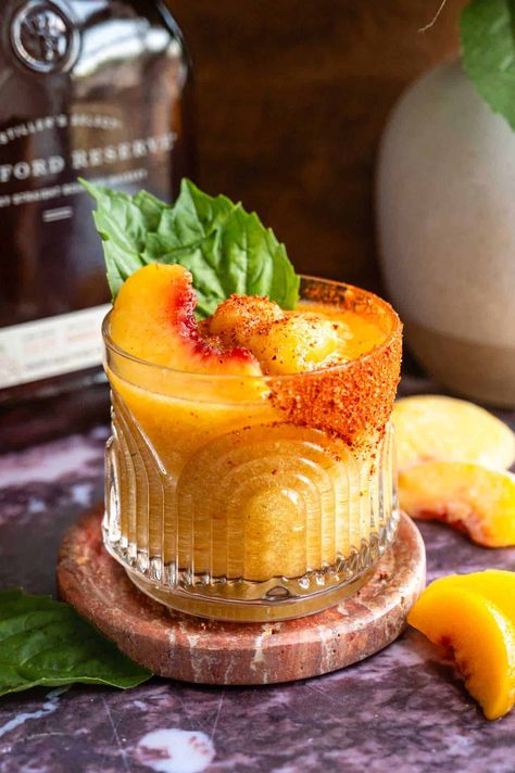 This bourbon slush with peach and hot honey is the ultimate cool and spicy treat for summer! It combines frozen peaches, bourbon, bitters, hot honey, basil, a dash of Tajin, and ice blended until smooth and creamy. It's peachy, spicy, and perfect for summer fun! Cream Puff Dessert, Brown Sugar Simple Syrup, Ice Blended, Peach Bourbon, Honey Cocktail, Puff Dessert, Sweet Bourbon, Frozen Peaches, Peach Cocktail