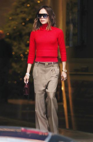 Victoria Beckham red and tan outfit Red And Camel Outfit, Red Sweater Outfit Winter, Camel Outfits, Sweater Outfit Winter, Red Sweater Outfit, Oversized Black Sunglasses, Camel Outfit, Tan Outfit, Victoria Beckham Outfits