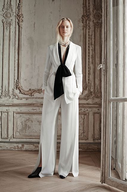 Pick The Unexpectedly Sexy One Some say the most seductive outfits are ones that are slim-fit, short, or shoulder-baring. We say: How can that possibly beat a disco-ready pantsuit with a plunging, bow-tied neckline and a pair of swingy, white pants? #refinery29 http://www.refinery29.com/alternative-bridal-style#slide-11 Alt Bride, Alternative Bridal, White Suit, 2015 Fashion, Spring Summer 2015, Fall 2015, Vogue Runway, White Fashion, Pre Fall