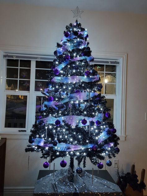 6ft, Black faux Christmas tree with cool white lights, wide blue and purple glitter tulle ribbon, blue, purple and silver ornaments, and silver glitter star topper. Galaxy Theme Christmas Tree, Purple And Blue Christmas Decorations, Blue And Black Christmas Decor, Blue And Purple Christmas Tree, Galaxy Christmas Tree, Grey Christmas Decor, Purple Christmas Tree Decorations, Galaxy Christmas, Faux Christmas Tree