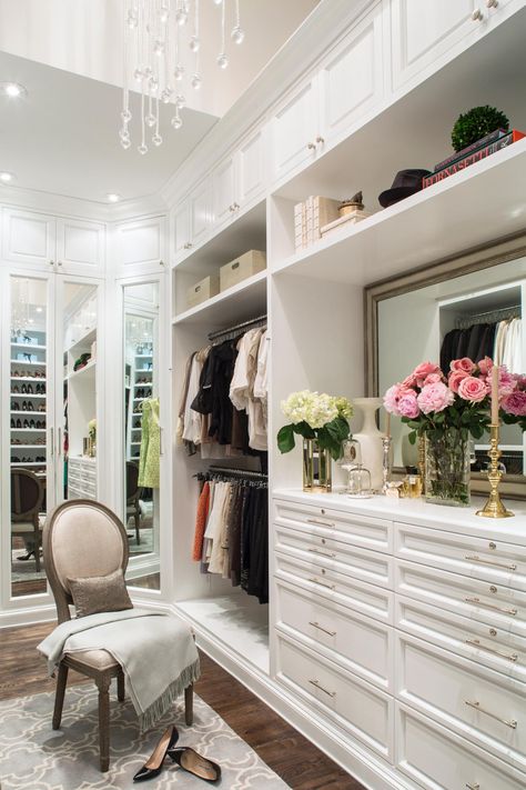 A demure Louis XIV-style chair provides a perfect perch for putting on shoes in this glamorous custom closet in a London loft. Cabinetry and shelving extend to the ceiling to maximize storage. Meanwhile, an elegant vanity offers display space for decorative and functional accessories in the transitional space. Dressing Design, Dressing Room Closet, Amazing Closets, Walk In Closet Design, Beautiful Closets, Luxury Closets Design, Real Estat, Bedrooms Ideas, Dream Closets