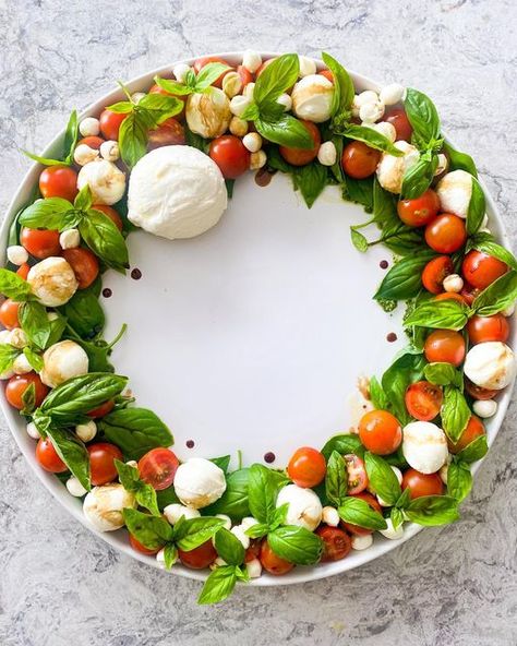 Debbie Gubbins on Instagram: "Christmas Caprese Wreath 🍅🍃 The most simple, prettiest Christmas salad you can make. Start off by brushing 1/2 cup basil pesto in a thick circle on a round plate. Place large single basil leaves on top in all different directions. Scatter whole cherry tomatoes over that and place a few halved cherry tomatoes among the whole ones. Arrange 2 tubs of 150g Bocconcini Mozzarella Cheese among the tomatoes followed by 1 tub of 150g Pearl Mozzarella balls. Finish with on Cheese Styling, Christmas Caprese, Caprese Wreath, Tomato Mozzarella Salad, Xmas Drinks, Christmas Salad, Mozzarella Balls, Christmas Salads, Mozzarella Salad