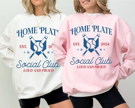 Baseball sweatshirt that says Home Plate Social Club Loud and Proud Est 2024 for the baseball season on a white sweatshirt and light pink sweatshirt with a blue and red graphic home plate and baseball bat Game Day Sweatshirt, Baseball Sweatshirts, Home Plate, Baseball Mama, Baseball Season, Club Shirts, Baseball Fan, Sports Mom, Mom Sweatshirt