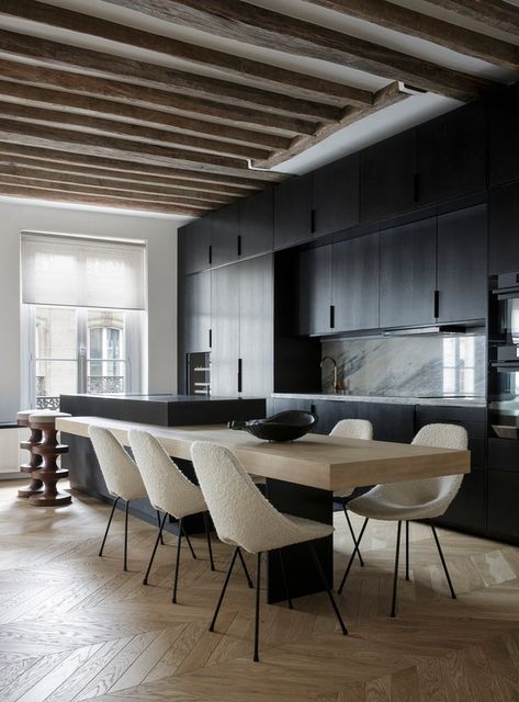 Located on one of the most elegant streets of Paris, where the major fashion stores and art galleries are concentrated, this apartment signed by Arthur Casas, co-authored by architect Marina Werfel, was designed to fulfill the wishes of the residents – a couple with two children – for practical, integrated spaces so they can welcome friends and accommodate a family life. Dark Stained Cabinets, Caesarstone Kitchen, Matte Black Kitchen, Minimalist Apartment, Timber Beams, Interior Minimalista, Apartment In Paris, Parisian Apartment, Paris Design