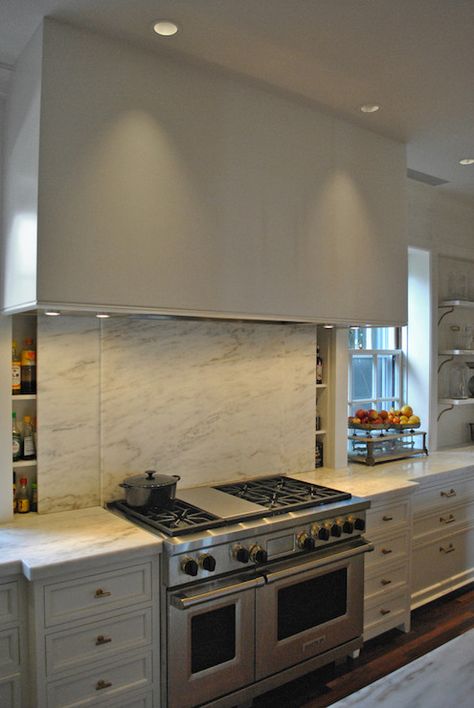 Innovative kitchen with stainless steel stove pairing with large range hood over sliding marble slab backsplash concealing slim spice rack. Backsplash Herringbone, Hidden Pantry, Stainless Steel Stove, Kitchen Innovation, White Kitchen Backsplash, Kitchen New York, Beadboard Backsplash, Custom Kitchens Design, Hidden Kitchen