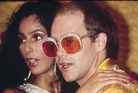 Elton John 70th Birthday His Epic Collection of Glasses 70s Fashion Men Hippie, Cher And Elton John, 60s Style Outfits, Elton John 70s, Elton John Sunglasses, 70s Aesthetic Fashion, 70s Fashion Hippie, 70s Fashion Men, 70s Fashion Disco