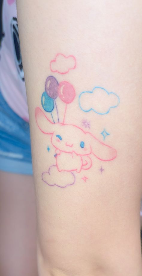 an arm in the foreground with pale skin and a tattoo of a bunny,  cinnamoroll. His body is outlined in pink with colorful sparkles and balloons. Cinnamon Roll Tattoo Sanrio, Cinnamon Roll Tattoo, Cute Pastel Tattoo, Sanrio Tattoos Ideas, Sanrio Tattoos Cinnamoroll, Sanrio Tattoo Design, Tattoo Ideas Sanrio, Cinnamoroll Tattoo, Cute Small Tattoos Sanrio