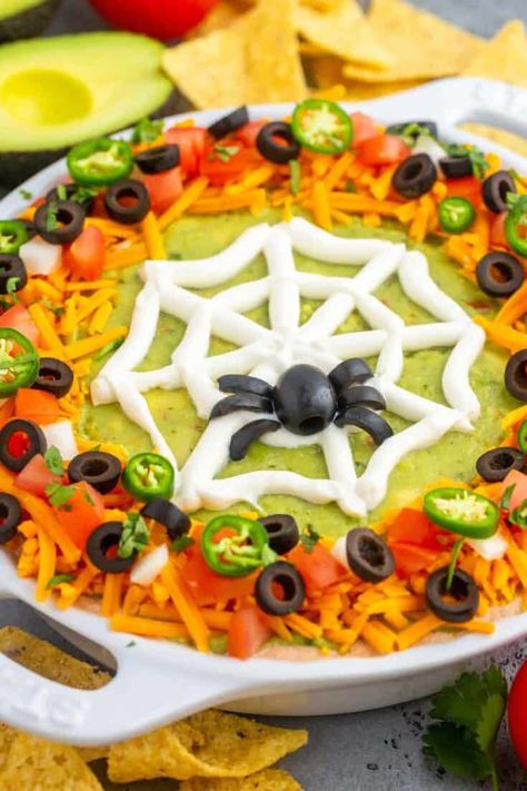 A delicious layered Halloween Taco Dip decorated with a fun spider web design is the perfect Halloween Party Food! This cold taco dip has layers of refried beans, seasoned cream cheese, and guacamole, and it’s easy to make, no cooking required. Food For Halloween Party, Spider Web Taco Dip, Halloween Dips, Spooky Brunch, Halloween Taco Dip, Halloween Boards, Halloween Bunco, Fun Halloween Snacks, Halloween Dip