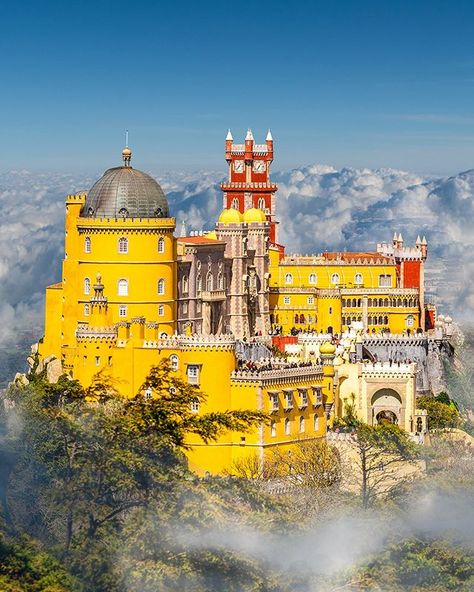 There's a reason why Pena Palace seen here seemingly floating amidst the clouds is one of the most iconic images of Sintra Portugal  This photo is it  That said many visitors stop by the resort town purely to poke their heads around the striking yellow castle and then split without having spent a single night in the town soaking up Sintra's romantic charms and sensational views of the Sintra Mountains. It's worth well more than a day trip as our best things to do in Sintra shows. Head to Wanderl Yellow Castle, Pena Palace, Lisbon Travel, Solo Travel Destinations, Sintra Portugal, Singapore Travel, Beautiful Castles, Travel Alone, Best Places To Travel