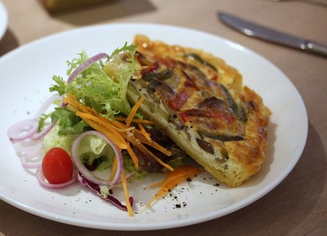 Slice of vegetarian quiche -- plated with a side of house salad. Vegetarian Quiche, Baked Appetizers, House Salad, News Cafe, Cafe Menu, Spaghetti, Salad, Cafe, Baking