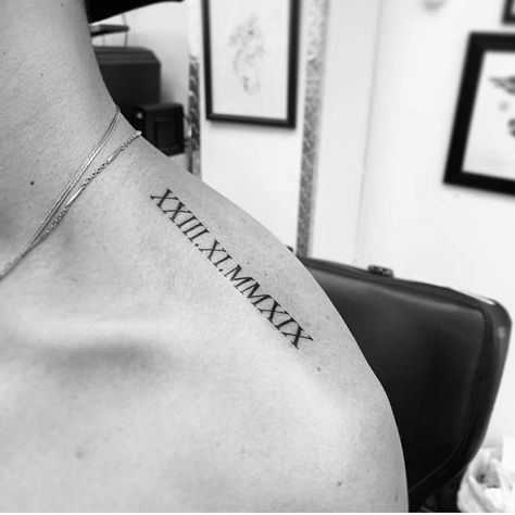 Shoulder Writing Tattoo Men, Tattoo Designs Men Roman Numerals, Roman Numeral Trap Tattoo, Shoulder Tattoo Roman Numerals, Shoulder Roman Numeral Tattoo, Mens Initial Tattoo, Roman Numeral Neck Tattoo, Traps Tattoo Men, Tattoo Shoulder Mens