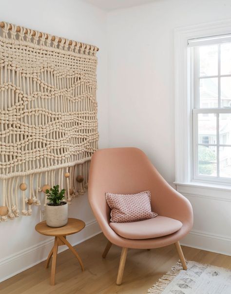 A bedroom corner is ideal for wind-down time. The blush armchair envelops the sitter almost like a hug. #bedroomcorner #bedroomideas #accentchair #blushaccentchair #neutralmodern #bhg Empty Wall Decor Ideas, Empty Wall Decor, Peach Chair, Pastel Wall Color Ideas, Pastel Wall Color, Peach Bedroom, Wall Color Ideas, Boho Dining Room, Woven Wall Decor