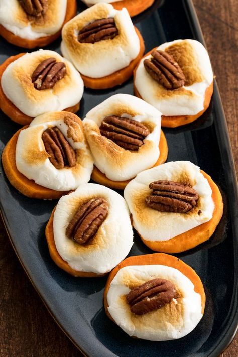 Sweet Potato Bites   INGREDIENTS  3 to 4 medium sweet potatoes, peeled and sliced into 1/4-inch-thick rounds 2 tbsp.  melted butter 1 tsp. maple syrup Kosher salt 1 (10-oz.) bag marshmallows 1/2 c. pecan halves  DIRECTIONS  Preheat oven to 400°. On a large baking sheet, toss sweet potatoes with melted butter and maple syrup and arrange in an even layer. Season with salt.   Bake until tender, flipping halfway through, about 20 minutes. Remove baking sheet from oven and switch oven to broil. Candies Yams, Sweet Potato Bites, Thanksgiving Potluck, Thanksgiving Appetizer, Sweet Potatoe Bites, Fall Appetizers, Nigel Slater, Potato Bites, Delicious Thanksgiving