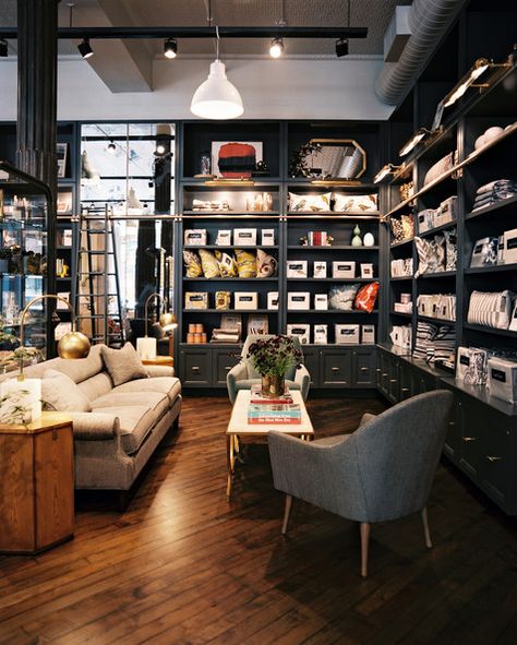 Exposed Ductwork - Gray built-in shelving surrounds a seating area Exposed Ductwork, Butik Design, Bookstore Design, Retail Lighting, Retail Shelving, Store Interiors, 카페 인테리어 디자인, Showroom Design, Retail Store Design