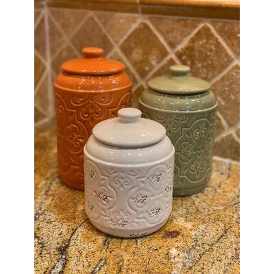 Whether you're the culinary expert of the family or you're looking for an updated pop of color in your kitchen, this spice color canister set of 3 is a perfect selection for your kitchen. The all-over pattern is highlighted by the glossy and rustic finish. This canister set is painted with 3 rich colors of burnt orange, deep sage, and cream. The round canisters serve as a storage solution for dry baking goods. Each canister comes with a matching color lid and seal. Measurements: 9.5X5.5X5.5(72oz Orange Kitchen Accents, Sage Green Kitchen Decor, Burnt Orange Kitchen, Pottery Canister Sets, 3 Piece Kitchen Canister Set, Farmhouse Kitchen Canisters, Orange Kitchen Decor, Green Kitchen Decor, Kitchen Storage Canisters