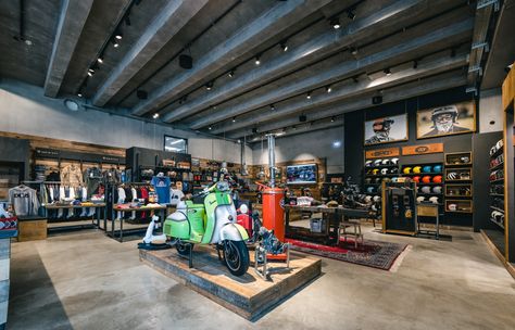 You can see a store for scooters. In the middle of the room is a green and white scooter on a wooden pedestal. On all walls of the room are wooden shelves or pedestals where helmets, jackets, T-shirts, glasses and bags are presented. Everything has a rustic style and is kept in concrete, wood and black optics. Scooter Store, Hipster Looks, Project Board, Shop Fittings, Cool Store, Wooden Planks, Design Language, Design Working, Wood Furniture