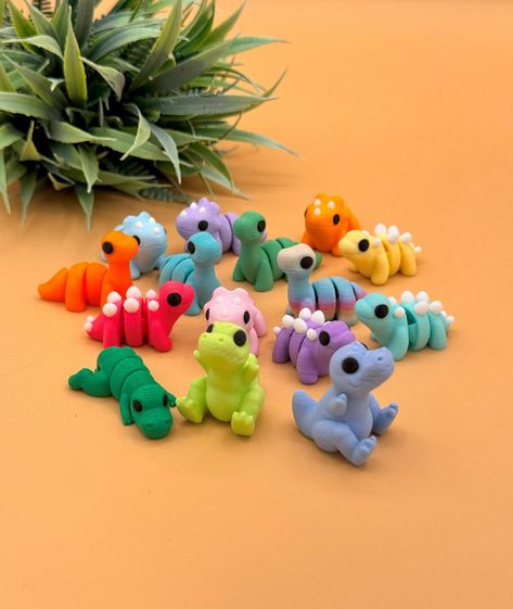 This random bundle of cute 3D printed dinosaurs toys includes miniature Triceratops, Brachiosaurus, Stegosaurus, and T-Rex. The 3D printed dinos come in a variety of colors, including pink, purple, orange, blue, dark green, mint green, yellow, and rainbow. We are constantly adding new models to our shop, so your order may include new dinosaurs or color variations not in this listing.  *Custom Order Please contact us for custom requests for any of our listings.  Authorized Seller for designs by Z 3d Printing Ideas Cute, Cute 3d Printing Ideas, 3d Print Ideas, 3d Printed Toys, Dinosaurs Toys, Cool 3d Prints, 3d Printing Ideas, Dinosaur Craft, 3d Printing Toys