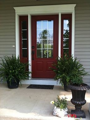 Country redwood by benjamin moore for my front door. Looks great with greige siding and white trim #paintedfrontdoor #curbappeal #benjaminmoore Gray House With Pink Front Door, Red Shutters White House, Dark Red Doors On Houses, Front Door With Windows On Each Side, Dark Red Front Door, Red Front Door Ideas, Taupe House, Potted Ferns, Red Doors