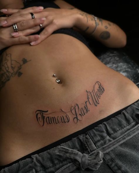 160 Exploring the Beauty of Women’s Stomach Tattoos: Designs and Inspiration - Psycho Tats Women’s Face Tattoo Ideas, Stomach Name Tattoo, Beautiful Words Tattoo, Side Of Torso Tattoos, Below Belly Button Tattoo, Lower Back Name Tattoos, Script Stomach Tattoo, Swirly Tattoos For Women, Sick Back Tattoos