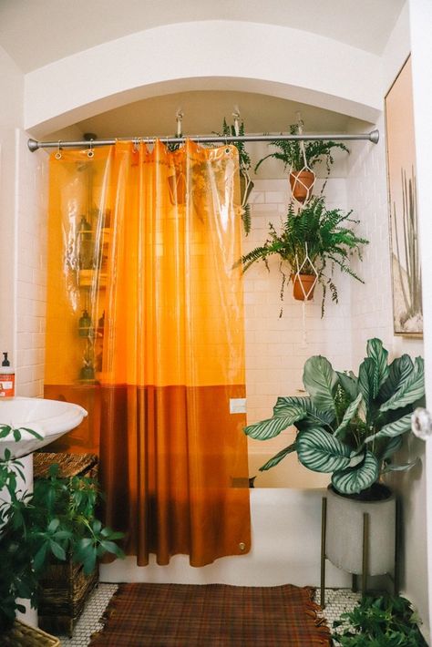 WOW - my $300 boho DIY bathroom makeover is insane! You won't believe the transformation of my boring old bathroom to fun boho bathroom. I started with the shower curtain and picked a fun clear orange shower curtain to be the anchor of decor. I then hung a lot of shower plants and did a shelf DIY project to make the whole space turn into a boho bathroom paradise. And it's such a cheap DIY project too! #boho #bathroom #diy #homedecor Aethstetic Bathroom Ideas, Bathroom Ideas Curtains, Bright Bathroom With No Windows, Funky Apartment Bathroom, Bathroom Design Shower Curtain, Crazy Bathroom Ideas Fun, Modern Funky Bathroom, Vintage Boho Bathroom Ideas, Curtain Shower Curtains