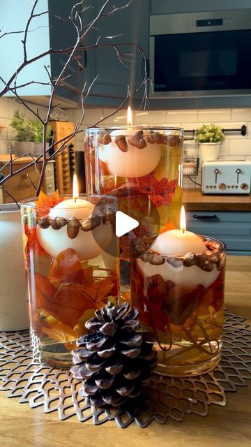 Jennifer’s🌿Home & Interiors on Instagram: "Floating Autumn candle Display 🍁🍂

Hi lovelies ,
I thought you might like to try this 😊
All you need is : 

* 3 Glass vases / From tall to small
* Artificial Autumn foliage / Garland cut sizes to fit your vases .
* Acorns picked or bought. I picked mine from the garden and spray painted them a copper colour
*Couple of jugs of water fill as desired amount
* Floating candles you can find them online Amazon & Temu or even in your local home decor store.

That’s it!! Hope you enjoy creating your own Display😊🥰

.
#falldecor #centerpiece #tabledisplay #autumnvibes #decorideas #craftyideas #fallvibes #autunmcolors #floatingcandles #candleideas #vasearrangement #acorns #displayhome #counter #kitchendecor #falldecorinspo #createexplore" Pumpkin Floating Candles, Autumn Floating Candles, Floating Candle Centerpieces Autumn, Fall Glass Candle Decor, Fall Leaf Candle Jar, Autumn Candle, Candle Displays, Vase Arrangements, Table Display