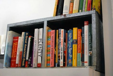 declutter kitchen countertops by storing cookbooks above the fridge via apartment therapy Display Cookbooks, On Top Of Fridge, Renters Kitchen, Steel Bookcase, Small Fridge Organization, Declutter Kitchen Counter, Cookbook Display, Top Of Fridge, Above Fridge