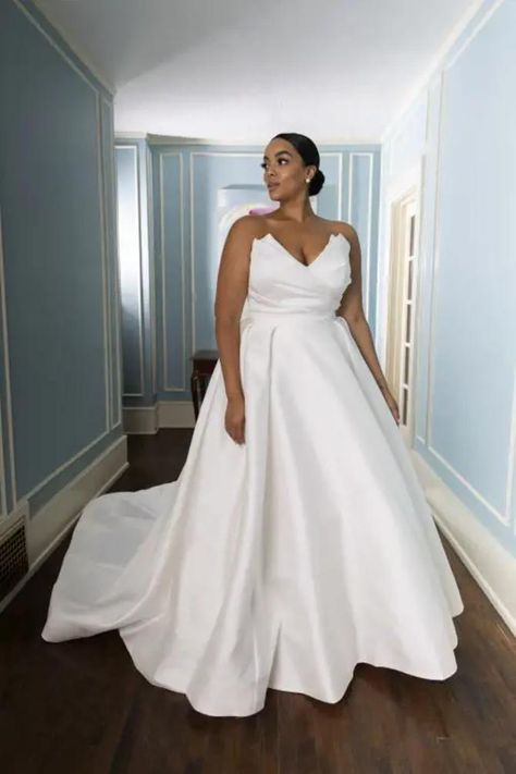 Martina Liana Plus Size Style #1557. 
                        <p>MODERN PLUS SIZE STRAPLESS SILK A-LINE WEDDING DRESS WITH LONG CATHEDRAL TRAIN</p>
<p>Simple, modern and oh-so-chic, Style 1557 takes timeless bridal design and adds a luxurious, glamorous twist. This show-stopping wedding gown is constructed in sumptuous ivory silk zibeline. It features a one-of-a-kind two-piece silhouette: a fitted fit-and-flare underdress and a gorgeous ballgown and overskirt. The underdress features a strapless bodice with architectural accents and a wrapped silk effect. When paired with the dramatic cathedral train on the over skirt completes this striking gown for an elevated, elegant appeal. The overskirt cuts a striking regal silhouette and when removed reveals the underdress, with its softly flared h Over Skirt, Bridal Design, Lansing Michigan, Cathedral Train, Gown Plus Size, Martina Liana, A Line Wedding Dress, Ivory Silk, Plus Size Wedding