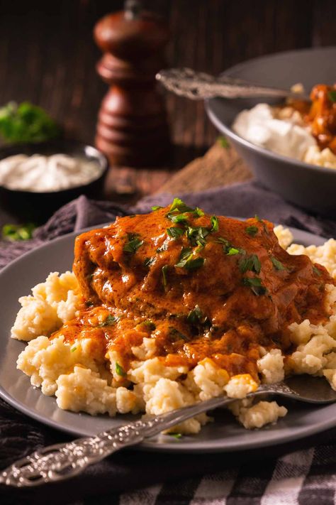 Chicken paprikash on top of spaetzle or nokedli on a plate with a dollop of sour cream on the side. Chicken Paprikash With Spaetzle, Chicken And Spaetzle Recipe, Chicken Paprikash Hungarian Authentic, Authentic Chicken Paprikash, Hungarian Chicken Recipes, Paprikash Chicken, Chicken Paprikash Recipe Crockpot, Spatzle Recipe Dishes, Chicken Paprikash Hungarian