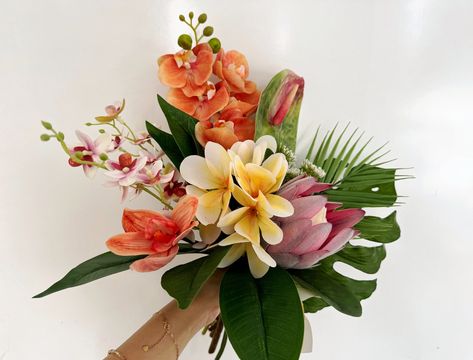 Colors orange, yellow, pink, green, etc. Flowers & Foliages plumeria, palm, protea, anthurium, monstera, etc. Material silk flowers, faux foliage, etc.  Introducing our exquisite Tropical Wedding Bouquet, an exquisite blend of vibrant colors and tropical blooms sure to add a touch of island paradise to your special day! This stunning arrangement features a perfect balance of plumeria, palm, protea, anthurium, and monstera leaves, each hand-selected to create an unforgettable bouquet. Radiating t Asian Flower Bouquet, Tropical Bohemian Wedding, Hawaiian Wedding Bouquet, Colorful Tropical Wedding, Tropical Flower Bouquet, Hawaii Wedding Flowers, Sunset Wedding Colors, Anthurium Bouquet, Boho Tropical Wedding