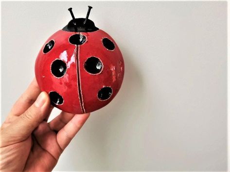 Ceramic ladybug sculpture is a red and black ladybug wall hanging, art object.It is the perfect spring decor item, a lovely Greek pottery item, made by our shop member, Opto. A ladybug of earthenware clay, with seven black dots on its back, made with lovely hollow spots and silver coloured, wire antennae.This ceramic ladybug is trully adorable. On the inside, hollow space there is a piece of sturdy wire to hang the ceramic bug on your wall.You can also stand it on any surface as an ornament or u Insect Ceramics, Ladybug Sculpture, Ladybug Ceramic, Ceramic Ladybug, Clay Ladybug, Ceramic Handbuilding, Ceramic Creatures, Insect Decor, Black Ladybug