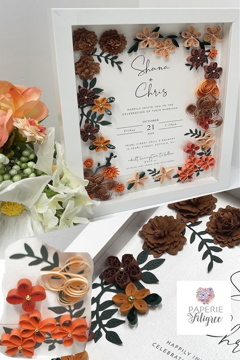 White shadow box displaying a fall wedding invitation keepsake made of fall colored paper flowers that mimic the wedding flowers. There are simple five petal flowers of varying fall colors and many have beads attached to the centers. Machine cut hand formed flowers and leaves are also included and they all surround the wedding invitation beautifully.. Quilled Wedding Invitations, Quilling Wedding Gift, Terracotta Fall Wedding, Wedding Quilling, Quilling Wedding, Wedding Invitation Keepsake, Quilling Wall Art, Wedding Gift For Couple, Wedding Unique