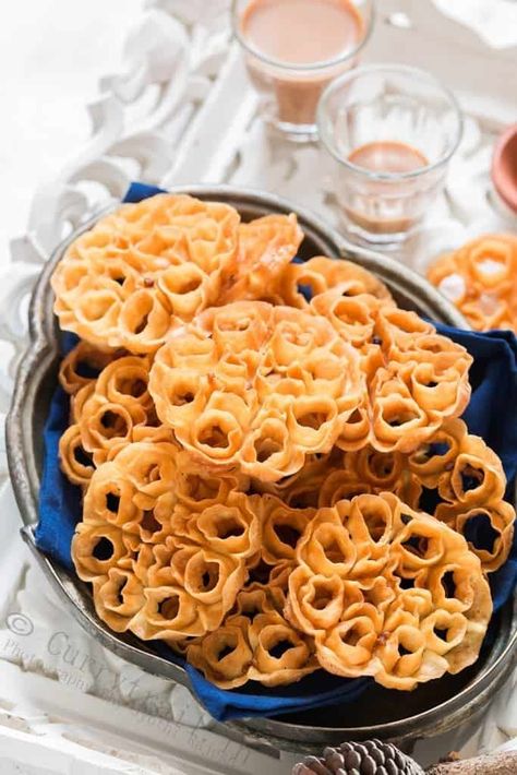 Rose cookies aka achu murukku is a traditional South Indian snack made during festivals in India. The pretty flower shape makes these murukku or cookies a very popular snack and goes perfectly with your evening tea. Festivals in India are always grand and colorful. That goes not just for clothes and decorations but for all the festive delicacies as well. Deepavali/Diwali is one of the grandest festival of lights in India and downright it’s one of my most favorite festival. I literally wait all y Sambhar Recipe, Rosette Cookies, South Indian Snacks, Flower Desserts, Christmas Donuts, Rose Cookies, Popular Snacks, Indian Dessert Recipes, Indian Sweet