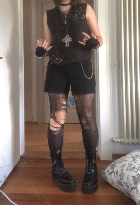 A mid-sized person/girl wearing a brown safety pin sweater vest with black shorts and patterned flower tights underneath, black fingerless gloves, black platform dr. Martens and multiple crystal rings and bracelets. 		The person is also wearing multiple silver necklaces. Dark Neutral Clothes, Summer Goth Masc, Goth Outfits Nonbinary, Dark Punk Outfits, Cute Masculine Outfits, Masc Goth Outfits Summer, Alt Outfits With Shorts, Punk Outfit Inspiration, Queer Punk Fashion