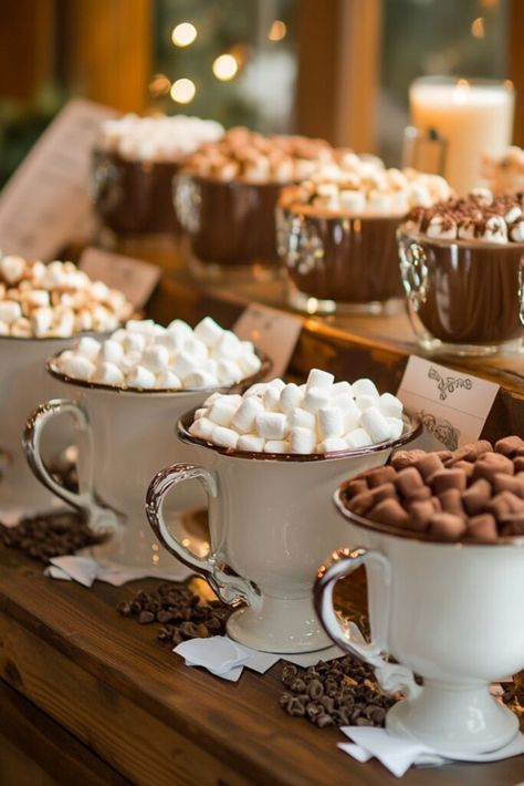 Winter wedding hot chocolate station with decorative mugs, marshmallows, whipped cream, and a variety of chocolate flavors. Hot Drinks Bar Ideas, Christmas Wedding Hot Chocolate Bar, Winter Wedding Hot Chocolate Bar, Hot Cocoa Bar Outside, Hot Chocolate Dispenser, Hot Toddy Bar, Hot Chocolate Bar For Wedding, Wedding Hot Cocoa Bar, Christmas Baking Squares