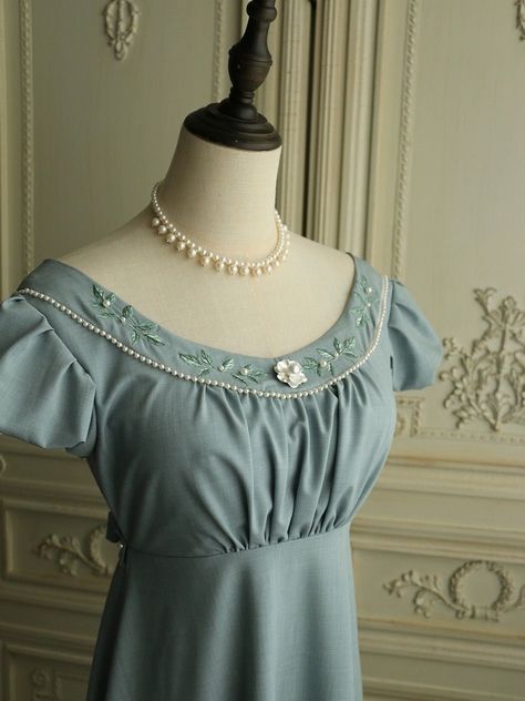 Experience the timeless elegance of the Regency era with this stunning grayish blue Bridgerton-inspired dress. Perfect for brides and special occasions, this dress beautifully blends vintage charm with modern sophistication. Timeless Design: Featuring a classic Regency silhouette, this dress boasts puffed sleeves and a gracefully flowing skirt. The floral appliqués and intricate beaded details along the neckline add a touch of refined elegance. Exquisite Details: The gown is adorned with delicate floral appliqués and beadwork, exuding sophistication and luxury. The back is tied with a ribbon belt, ensuring a flattering fit and adding to the dress's elegant design. Premium Quality: Made from high-quality fabric, this dress offers a soft and luxurious feel. The meticulous craftsmanship is ev Regency Silhouette, Regency Era Dress, Antoinette Dress, Nontraditional Wedding Dress, Champagne Evening Dress, Wedding Dresses High Low, Floral Applique Dress, Bridgerton Inspired, Fairy Wedding Dress