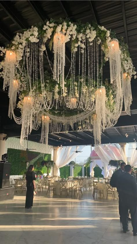 Have you ever seen anything like this? Our chandelier is a mixture of ivory hanging flowers, greenery leaves  and crystal beads followed by light that illuminates all around.  #Royalgarden #LuluJaramillo #Royalevents Crystal Hanging Decor Wedding, Chandelier Tent Wedding, Flowers Hanging From Ceiling Wedding, Hanging Flowers From Ceiling, Wisteria Chandelier, Flower Chandelier Wedding, Floral Chandelier Wedding, Bridal Suite Decor, Hanging Flowers Wedding