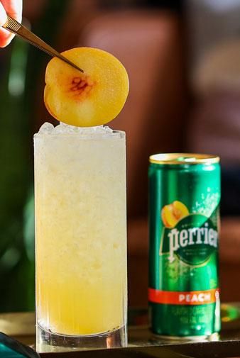 Peach Swizzle | Perrier Non-Alcoholic Mocktail Recipes Mocktail Recipes, Peach Puree, Peach Slices, Mocktail Recipe, Mineral Water, Beverage Cooler, Sparkling Water, Fresh Lemon Juice, Simple Syrup