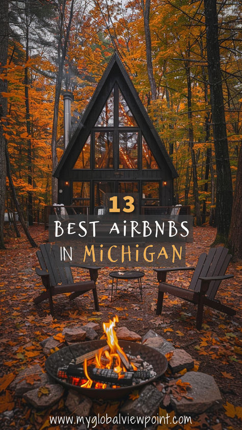 Cozy A-frame cabin surrounded by vibrant autumn foliage in Michigan, featuring a fire pit with Adirondack chairs and warm outdoor lighting, perfect for a serene getaway. Lake Airbnb, Michigan Airbnb, Michigan Lake House, Vacation Cabins, Michigan Cottage, Michigan Adventures, Cabin Trip, Romantic Cabin, Michigan Vacations