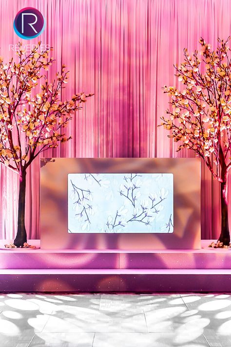 Looking for event design ideas? We brought the outside in for this amazing indoor garden party set-up: using gently pleated drapes and clever lighting, we set up a real showstopper of a backdrop to the bespoke DJ booth with our raised set design. Our magnolia trees and illuminated screen with a floral print were the perfect finishing touches… ideal for summer parties. #summerevents #summerparties #summerweddings #partyideas #rosepink #djbooth #eventdesign #events #reveriesevents Dj Backdrop Wedding, Wedding Dj Booth Decor, Unique Dj Booth, Pink Dj Booth, Wedding Dj Booth, Event Design Ideas, Indoor Garden Party, Pleated Drapes, Dj Booth