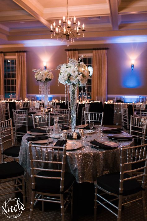 Black Floor Length Table Cloths with a Silver Sequin Overlay, Silver Charger Plate & Pleated Black Napkin Silver Sequin Tablecloth, Black And Silver Reception Decor, Black And Silver Banquet Decorations, Silver Debut Theme, Black And Silver Masquerade Party, Black And Silver Wedding Reception, Black White And Silver Quince, Silver Quince Decorations, Black White And Silver Wedding Reception