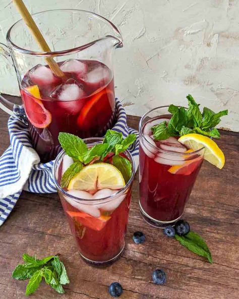 Sweet and refreshing blueberry iced tea is the perfect summertime BBQ picnic drink.  Easy to make using brewed tea and blueberry simple syrup. Fruit flavored iced tea is our go-to drink recipe because they are naturally sweet.   #icedtea #icetea #fruittea #tearecipe #nonalcholicdrinks #summerdrinks #drinksforacrowd #blueberries Blueberry Syrup Recipe, Fruit Tea Recipes, Picnic Drinks, Blueberry Simple Syrup, Cold Brew Iced Tea, Mint Sugar, Blueberry Tea, Blueberry Syrup, Free Lunch