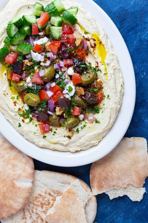 Loaded hummus is the perfect appetizer. Creamy hummus topped with delicious fixings such as tomatoes, onions, olives and feta. Serve this layered hummus at your parties and gatherings with veggies, pita or pita chips for the ultimate experience! Layered Hummus, Loaded Hummus, Baked Feta Recipe, Muhammara Recipe, Hummus Platter, Creamy Hummus, Hummus Recipe Homemade, Hanukkah Party, Tzatziki Recipes