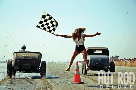 Sara Francello does a split over a starting line pylon, all in an attempt to escape a sandy shower from two flathead-powered Fords. Racing Trophy, Belly Tank, Rockabilly Cars, Demolition Derby, Starting Line, Car Photo, Bad To The Bone, Checkered Flag, Bikes Girl