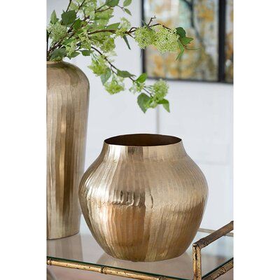 This table vase is the distinct glamorous accent you've been looking for. It's made of aluminum with a wide tulip shape that features elegant curves. The distressed metal has a chiseled look for an extra touch of texture for an extra dimension in your decor set-up. We love that the gleaming gold finish catches and reflects light, brightening up any room. This table vase as a centerpiece on an end table or as part of a vase collection on your mantelpiece. Size: 11.4" H x 13.5" W x 13.5" D | Etta Large Gold Vase, Golden Vase, Bronze Decor, Gold Trend, Gold Bowl, Gold Vase, Brown Vase, Vase Collection, Gold Vases