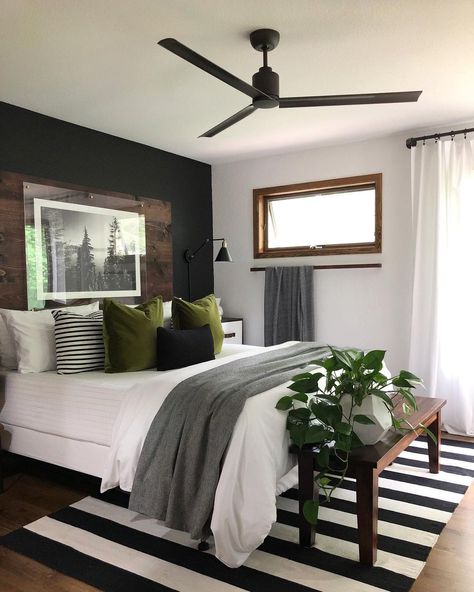 Homeowners looking for a sleek and minimalistic aesthetic, your search is over. This beautiful monochrome bedroom features a gorgeous jet-black accent wall with a rich mahogany headboard. A classic pairing of black and white presented by the walls is mimicked by the striped rug underneath the bed. Gray Accent Wall Bedroom, Moody Master, Black Accent Wall, Monochrome Bedroom, Black Accent Walls, Grey Headboard, Black Headboard, Bedroom Accent, Accent Wall Bedroom