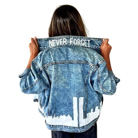 DESCRIPTION EACH PIECE IS MADE TO ORDER, HAND PAINTED BY GLORIA AND HER TEAM IN THEIR NYC STUDIO PRODUCT DESCRIPTION 10% of proceeds to benefit Tunnel To Towers Foundation, to assist in their efforts to raise money for our Nations hero's and their families. Lighter blue denim wash. Outline if NYC skyline, including Twin Towers, painted along entire bottom hem of jacket. NEVER FORGET painted on collar. Collar painted white. Signed @wrenandglory. Due to each piece being hand painted, each jacket m Denim Jacket Custom Ideas, Graphic Denim Jacket, Creative Jeans, Custom Jean Jacket, Nyc Studio, Nyc Skyline, Perfect Denim, Fashion Tutorial, Blue Jean Jacket