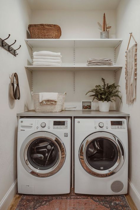 A small laundry room featuring a  front loader washer and dryer, open shelving, and practical space utilization. Small Laundry Room Front Loaders, Front Loader Laundry Room, Front Loader Laundry Room Ideas, Small Laundry Room Decor Ideas, Small Laundry Room Decor, Small Laundry Area, Laundry Room Decor Ideas, Small Laundry Room Ideas, Laundry Room Update