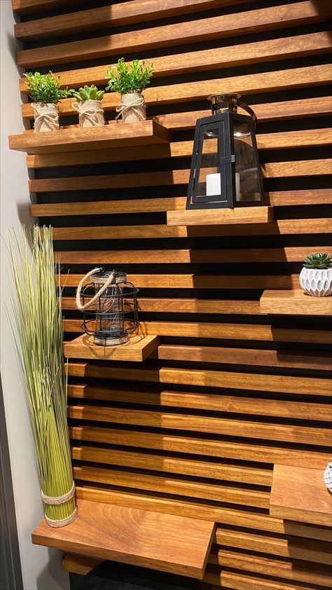 This wall design, made from black Valcromat and Iroko, brings not only nature & warmth into any room, it also can serve as a shelving unit. #walldesign #wooddesign #shelvedesign #woodwall #interiordesign Slat Wall With Moveable Shelves, Outdoor Wall Shelf, Horizontal Wood Slat Wall With Shelves, Wood Slate Accent Wall With Shelves, Horizontal Wall Slats, Wood Panel Wall With Shelves, Wood Slat Shelf Wall, Wood Slat Wall Horizontal, Horizontal Wood Slat Wall Bedroom