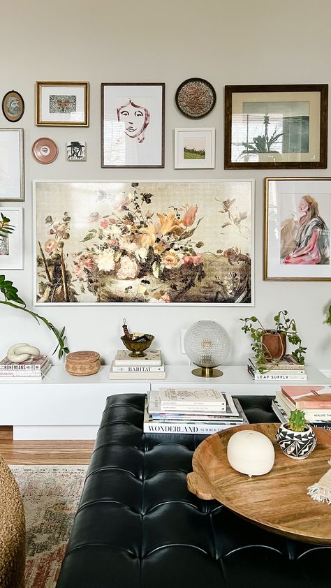 A gallery wall was built around a 55" Samsung Frame TV and surrounded by piles of books and plants for a cozy, layered and lived-in feeling Samsung The Frame Gallery Wall, Samsung Frame Tv Gallery Wall, Tv Gallery Wall Ideas, Frame Tv Gallery Wall, Tv Interior, Tv Gallery Wall, Gallery Wall Ideas, Printable Vintage Art, Frames Wall